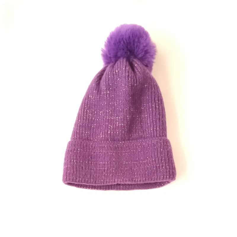 Bonnet violet pailleté à revers et gros pompon, vu de face sur fond blanc.