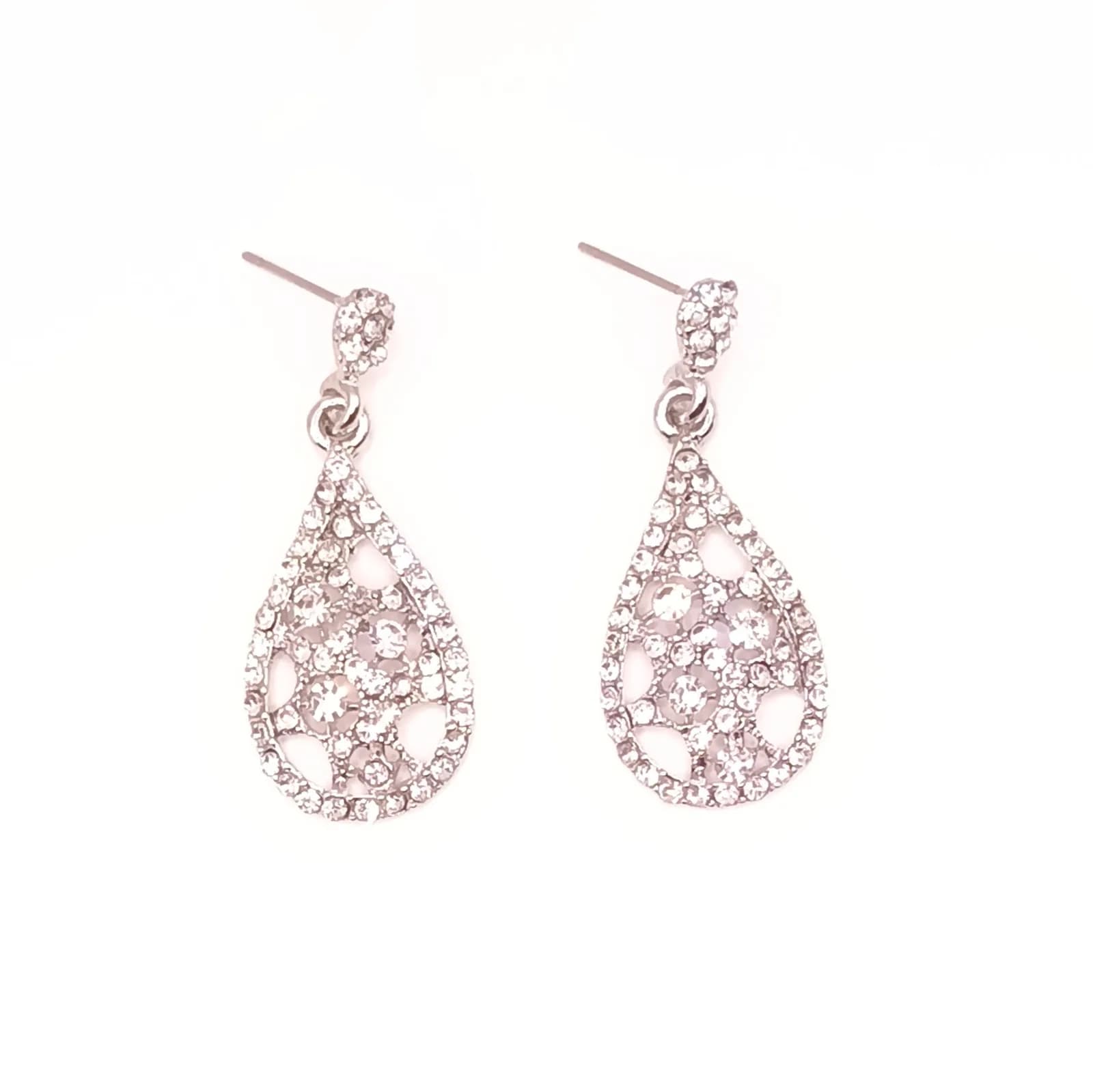 Paire de boucles d'oreilles pendantes en goutte ajourée argentée sertie de pierres scintillantes, vue de face.