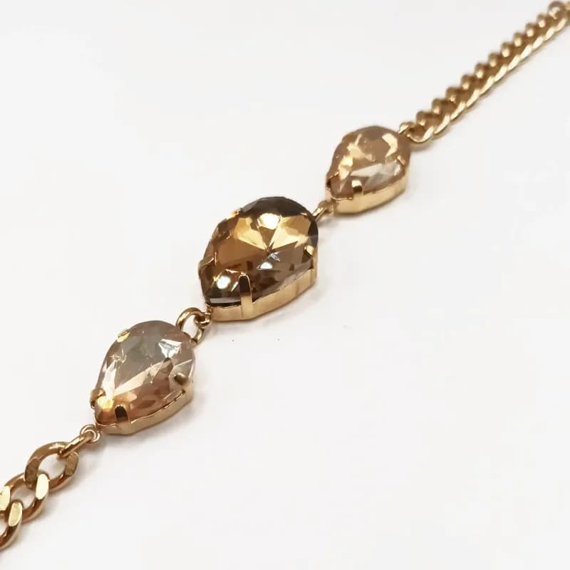 Bracelet chaîne gourmette dorée à trois cristaux en forme de goutte - vue de trois quarts sur les cristaux