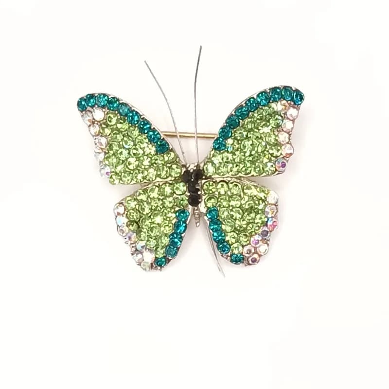 Broche papillon pavée de pierres scintillantes vertes et turquoise vue de face.