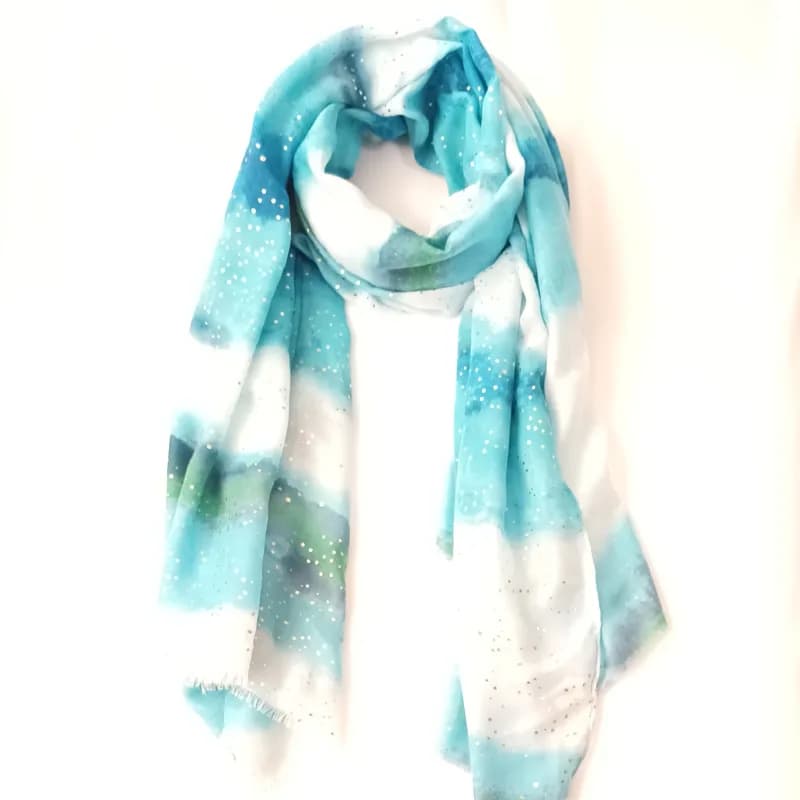 Foulard aquarelle turquoise et blanc à pois scintillants, noué en boucle et vu de face.