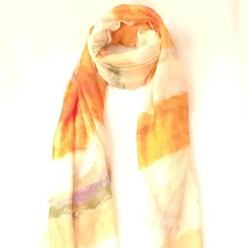 Foulard aquarelle orange, jaune et ivoire à pois scintillants, noué en boucle et vu de face.