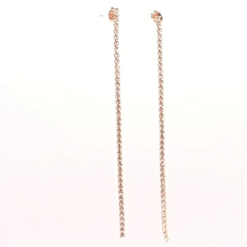 Boucles d'oreilles très longues à une seule rangée de pierres claires, vues de face sur fond blanc