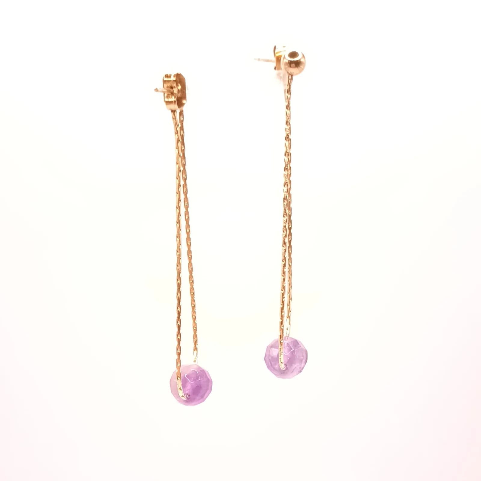 Boucles d'oreilles pendantes par une chaîne dorée et perle violette, vues de face sur fond blanc
