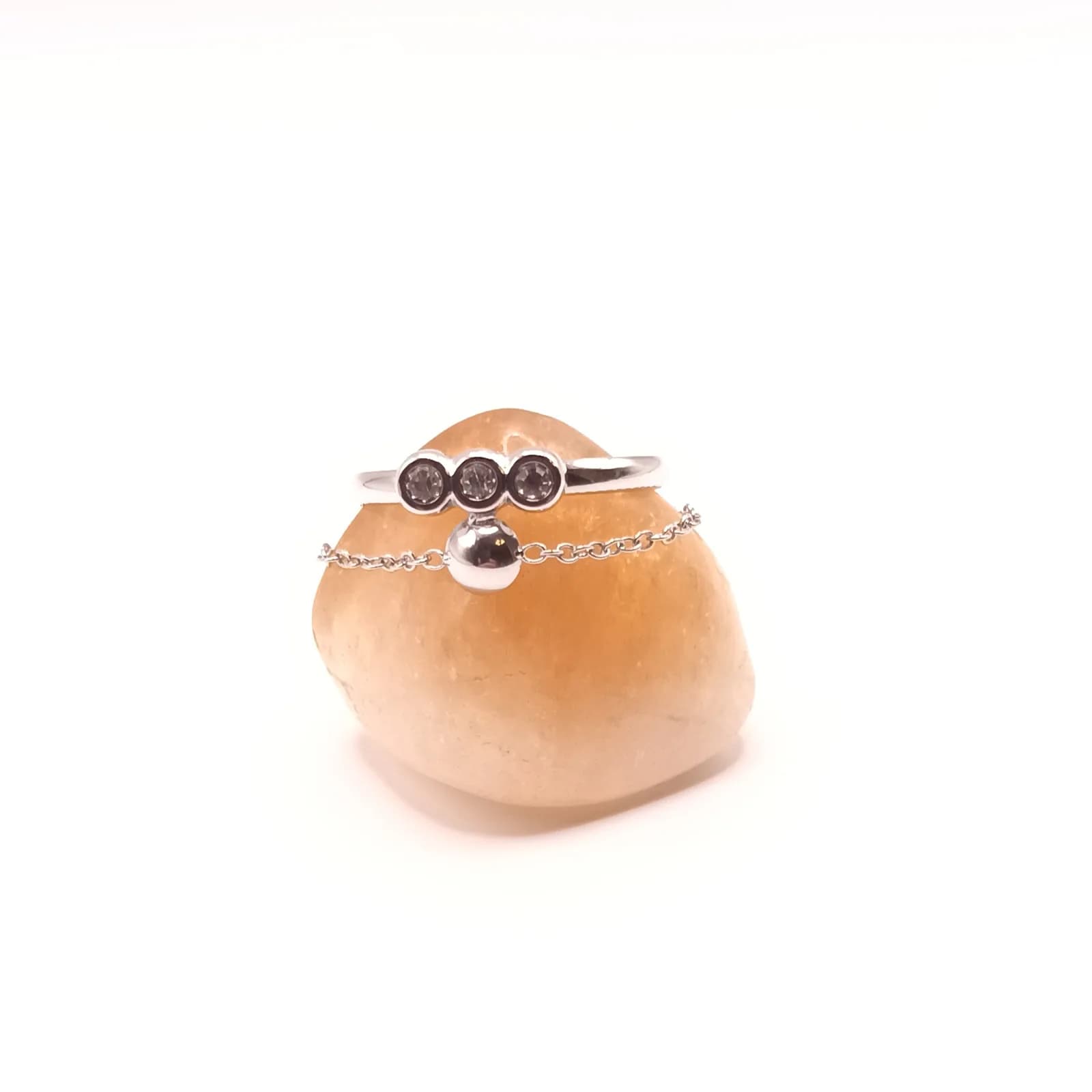 Détail des trois strass sertis clos et de la chaînette mobile de la bague