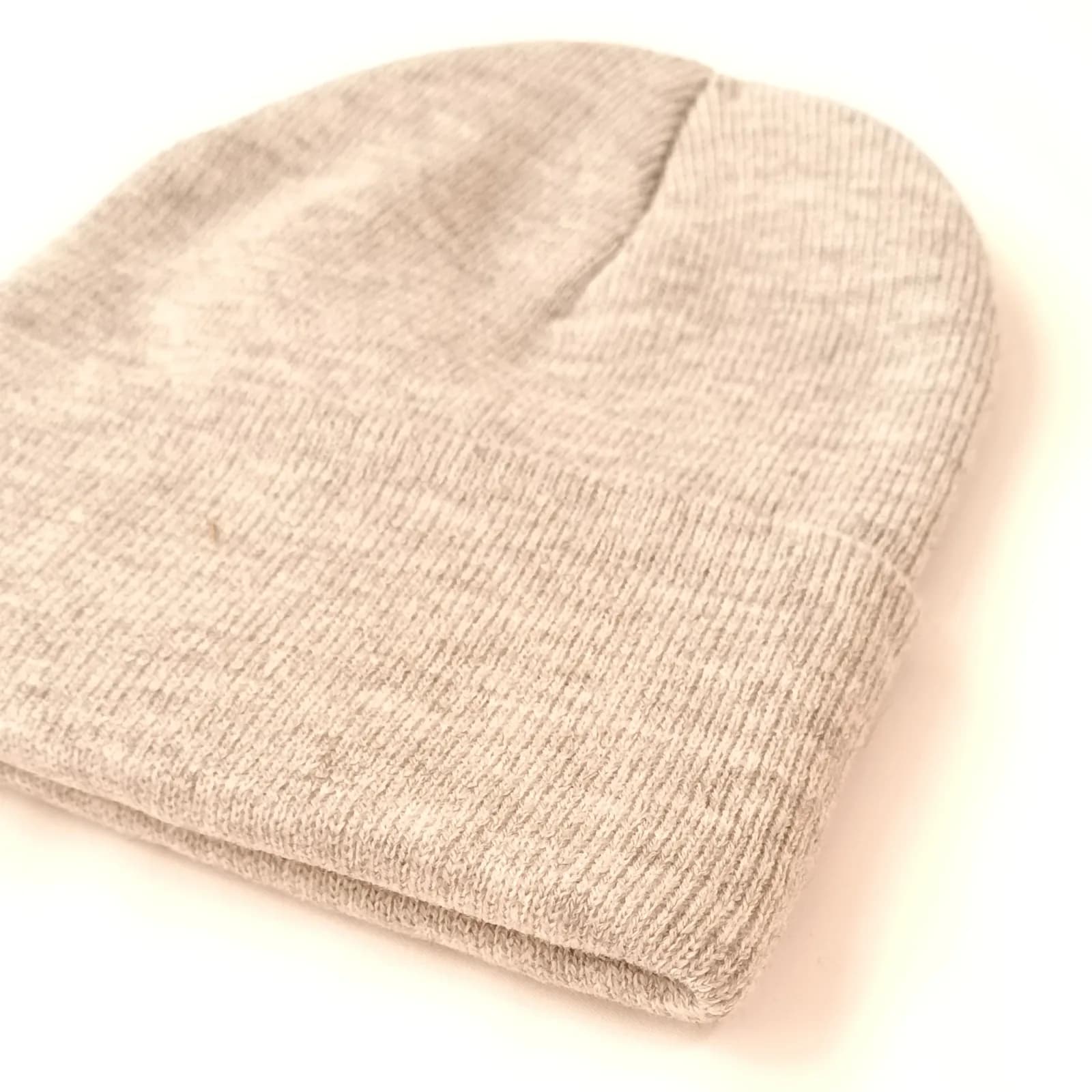 Gros plan sur la maille chinée et le revers du bonnet beige.