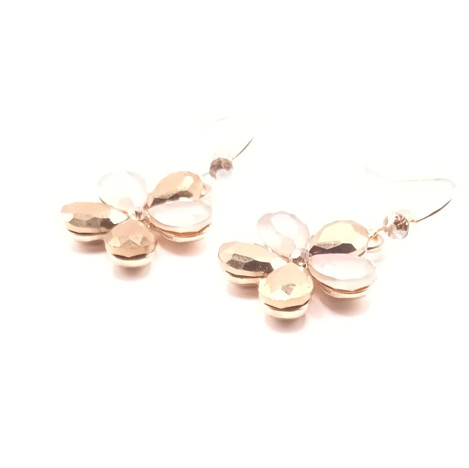 Boucles d'oreilles fleur à pétales facettés posées à plat, vue de biais.
