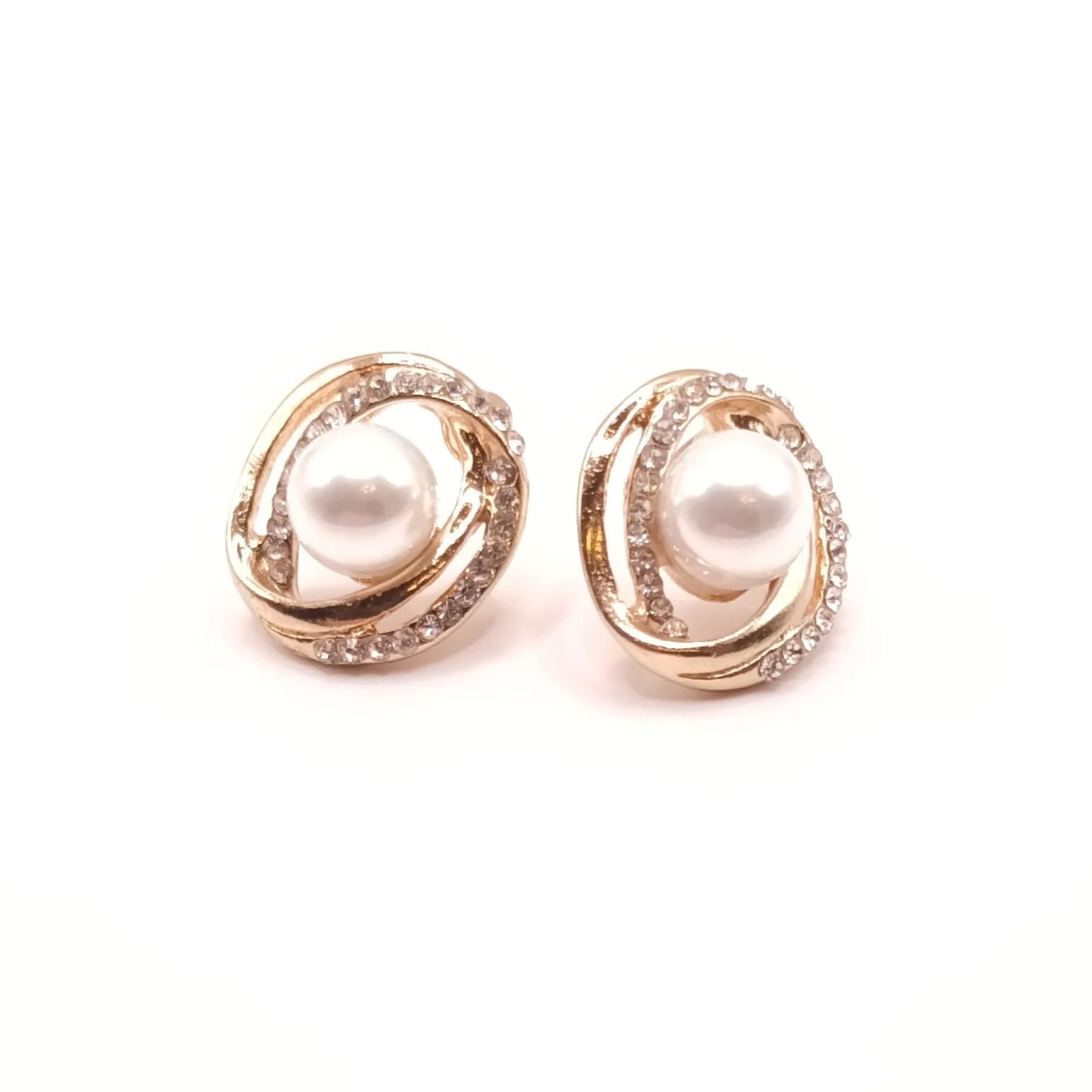 Paire de boucles d'oreilles puces en spirale argentée, avec une perle nacrée au centre et des pierres scintillantes.