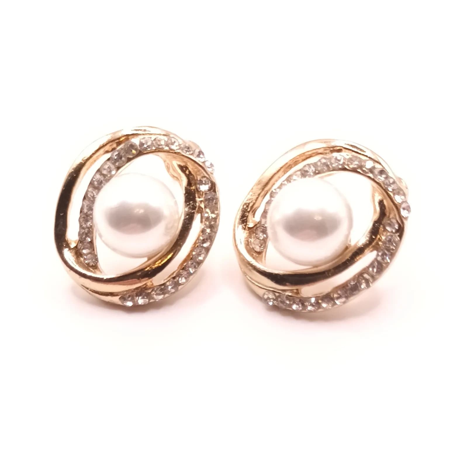 Boucles d'oreilles spirale argentée à perle nacrée, vue de face.