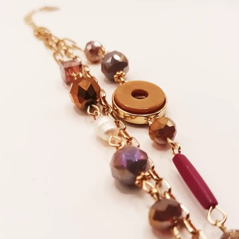 Bracelet triple chaîne dorée à perles facettées et anneau central - gros plan sur les perles et l'anneau central