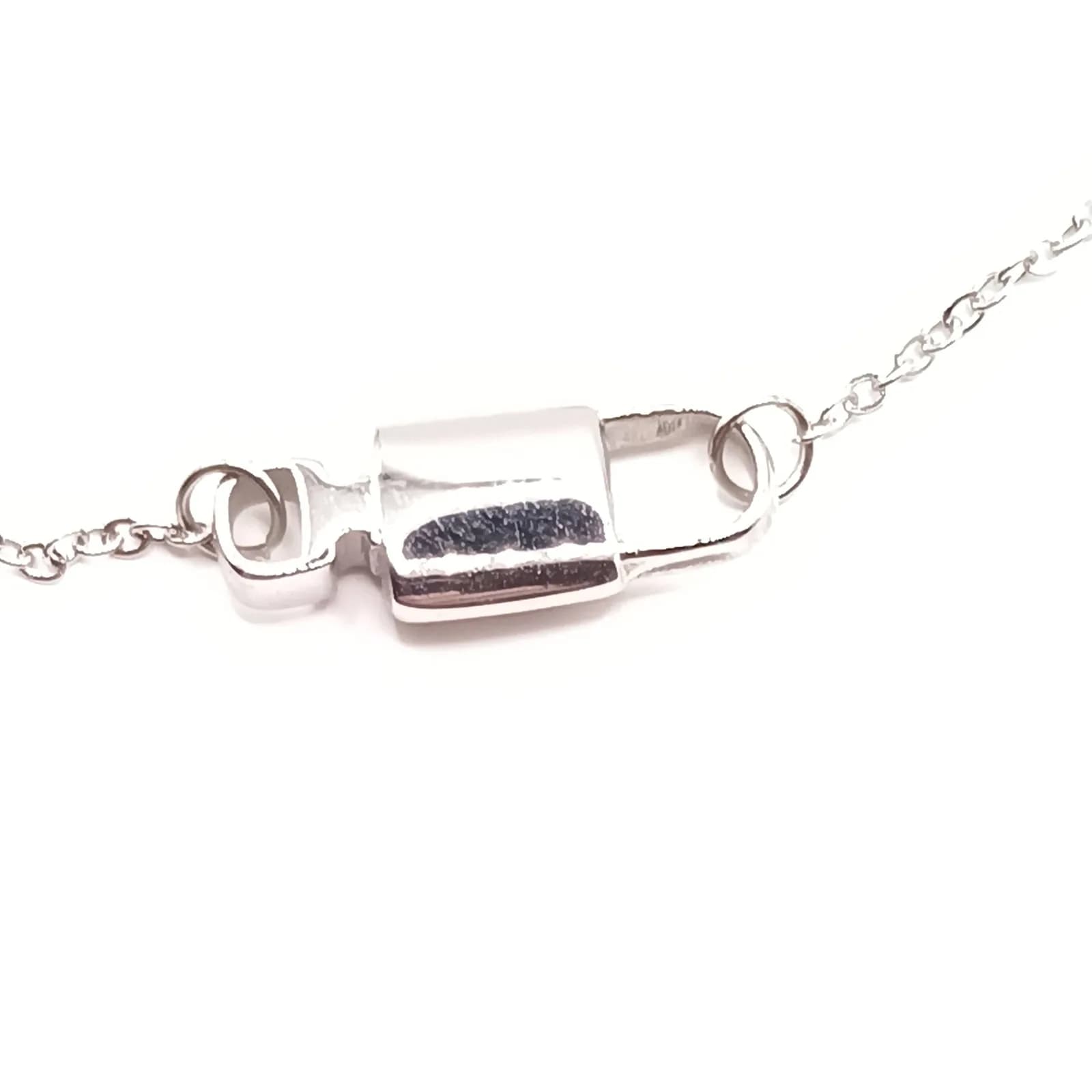Profil du cadenas argenté poli relié à la chaîne du bracelet.