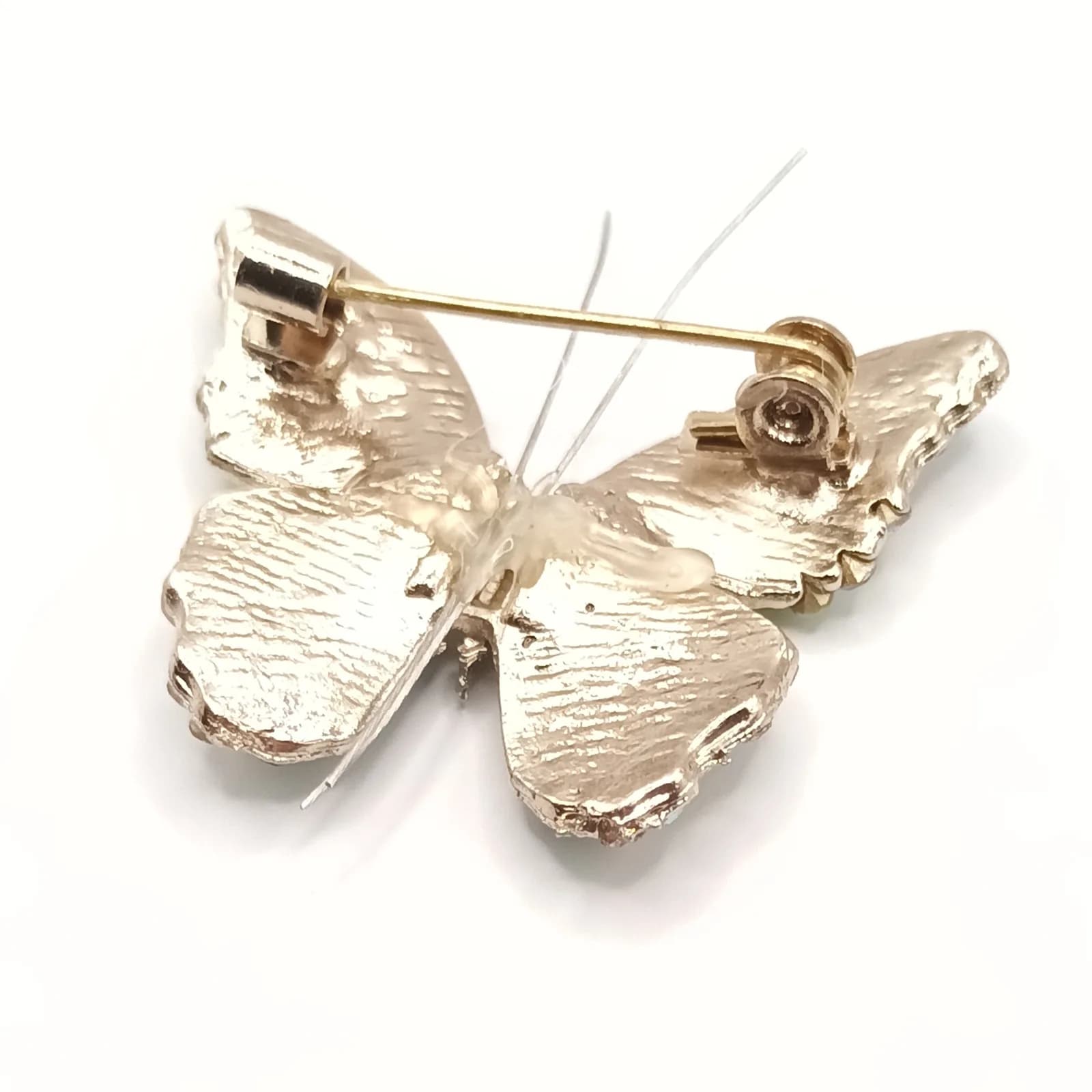 Dos doré de la broche papillon avec son épingle de sûreté.