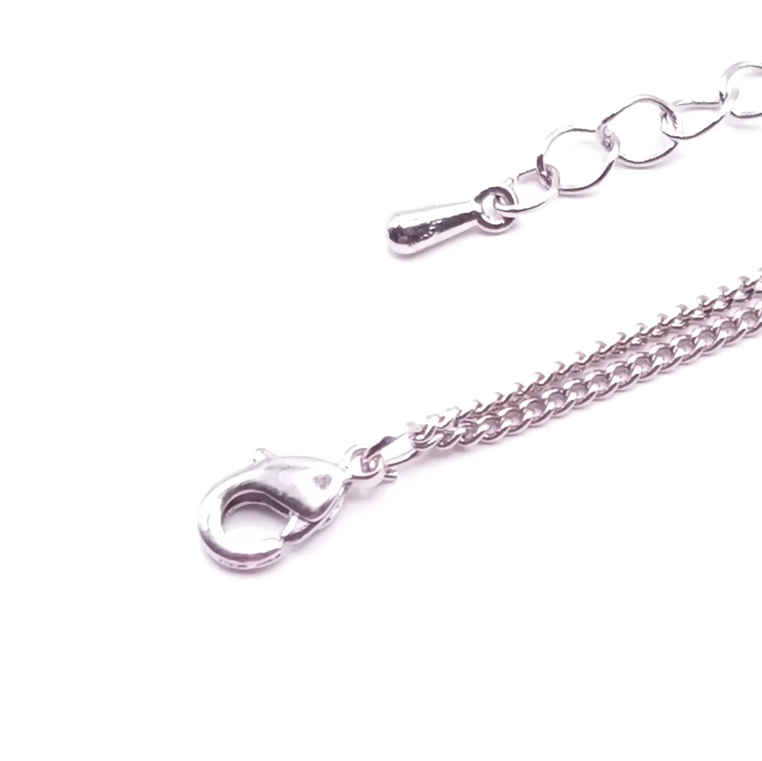 Fermoir mousqueton ton argenté et chaînette d'extension du collier.