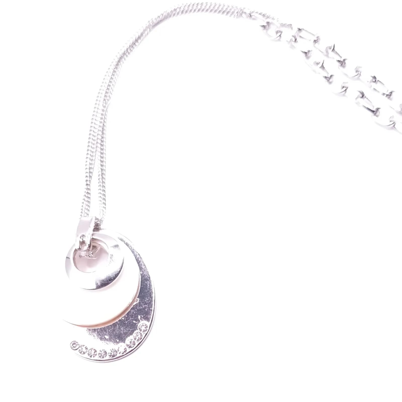 Pendentif superposé avec anneau argenté, disque nacré et ovale serti, vu de côté.