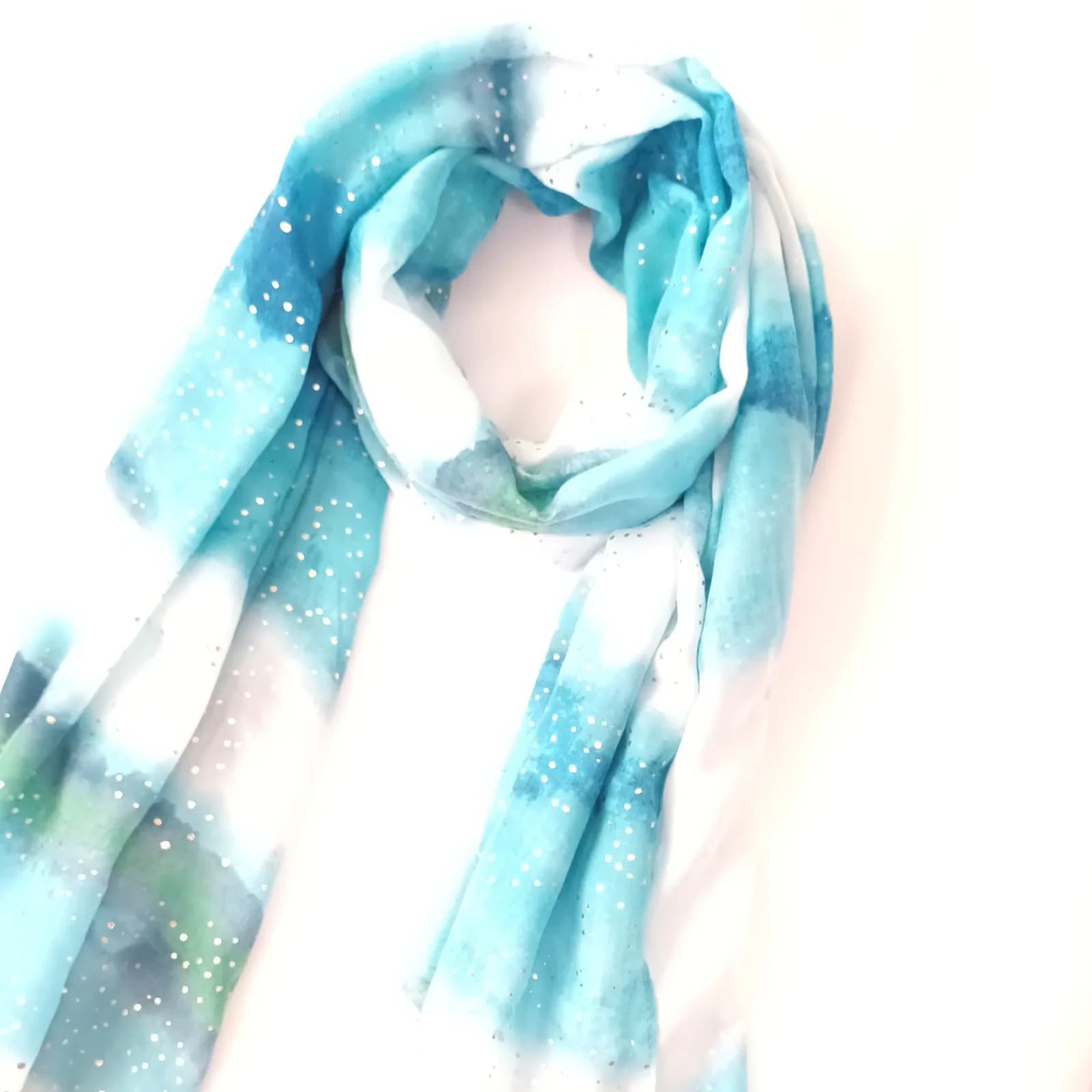 Foulard turquoise et blanc à pois métallisés, drapé en boucle et vu de biais.