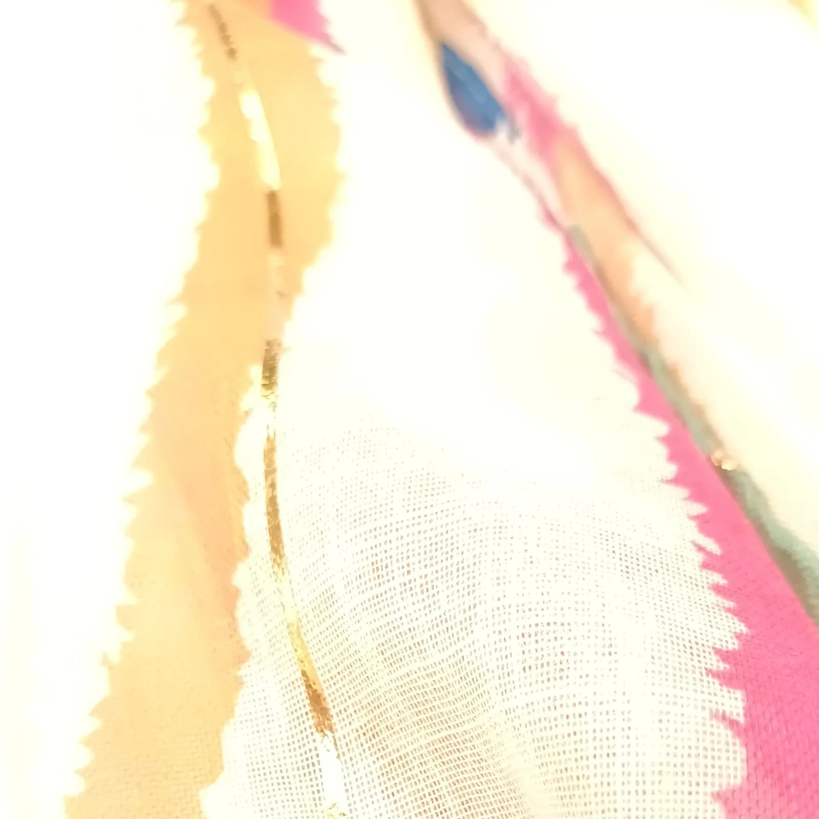 Détail des vagues rose, pêche, bleue et vert d'eau rehaussées de lignes dorées.