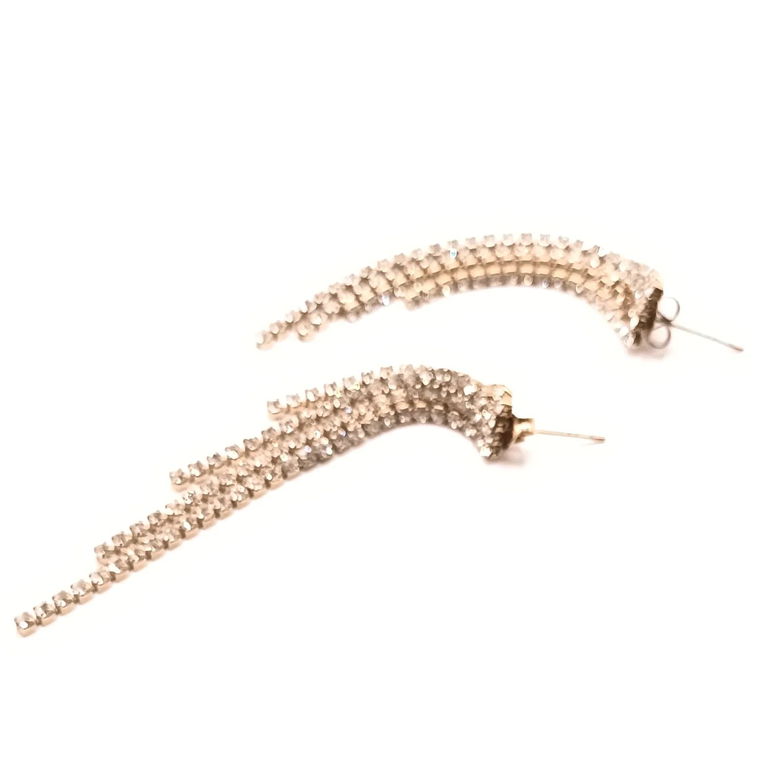 Paire de boucles d'oreilles pendantes à rangs de pierres claires, posées à plat en arc de cercle